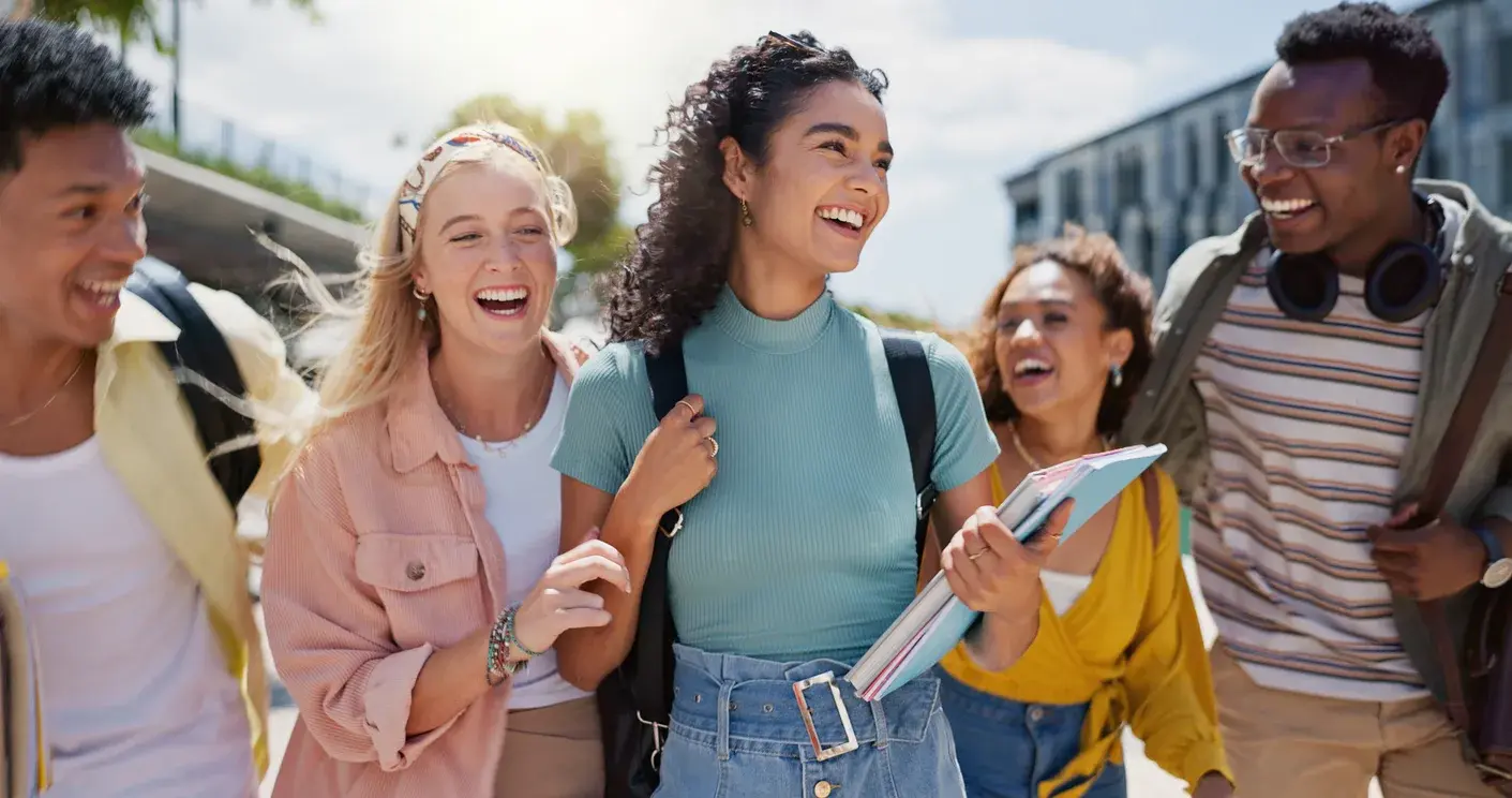 A diverse group of happy students walking together on campus